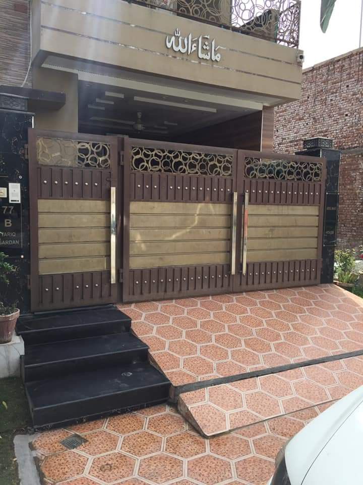 a car is parked in front of a building with wooden doors and stairs leading up to it