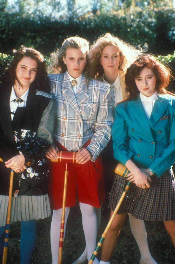 four young women standing next to each other holding croquets and canes