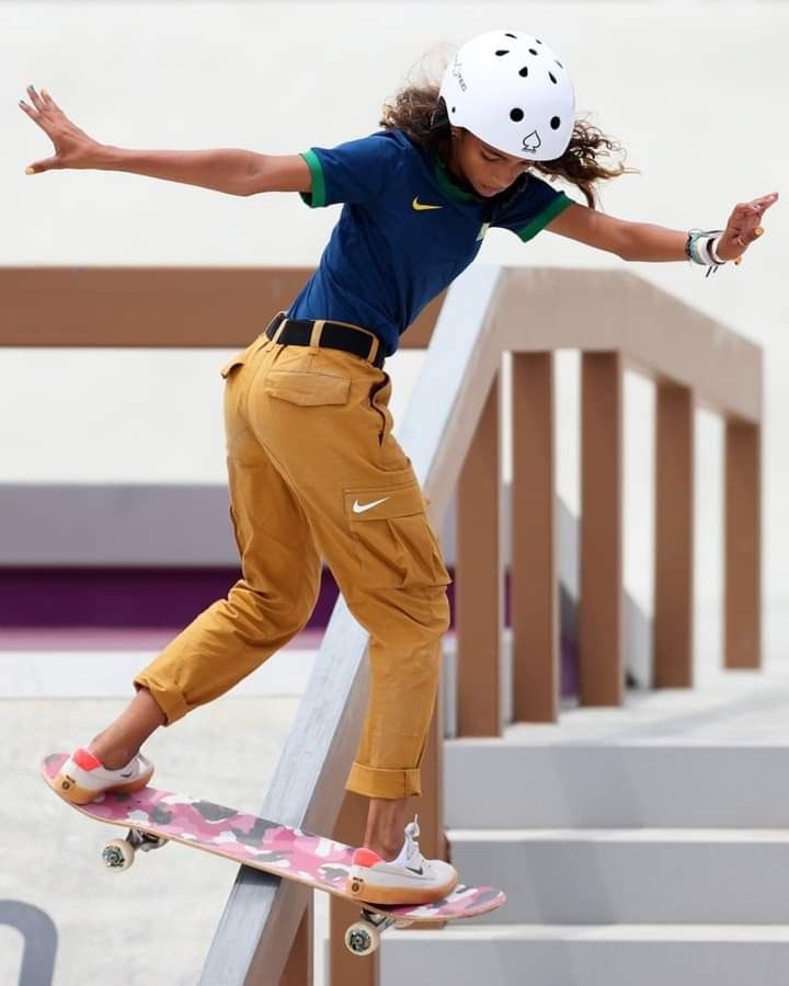 a young man riding a skateboard up the side of a rail on top of cement steps