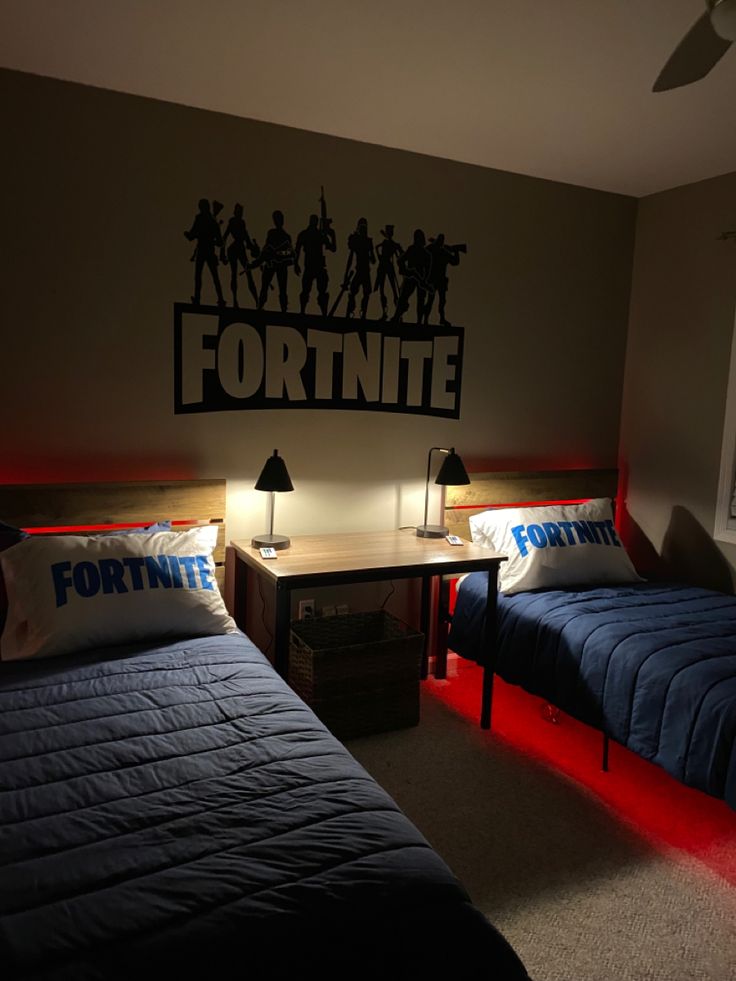 two beds in a room with lights on and the wall behind them has a fortnite sign