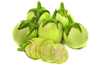 green tomatoes and sliced cucumbers on a white background