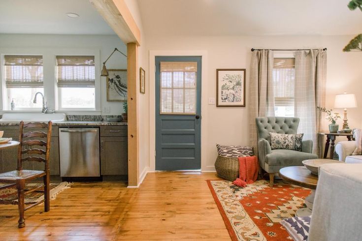 a kitchen and living room are separated by an open door to the dining room area