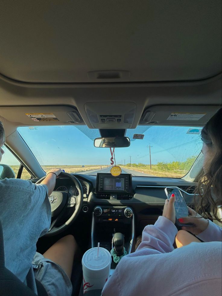 two people sitting in the driver's seat of a car