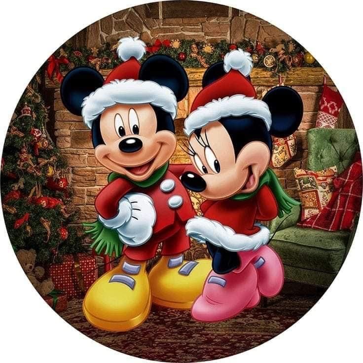 two mickey and minnie mouses standing in front of a fireplace with christmas decorations on it