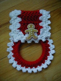 a red and white crocheted christmas stocking with a gingerbread man on it