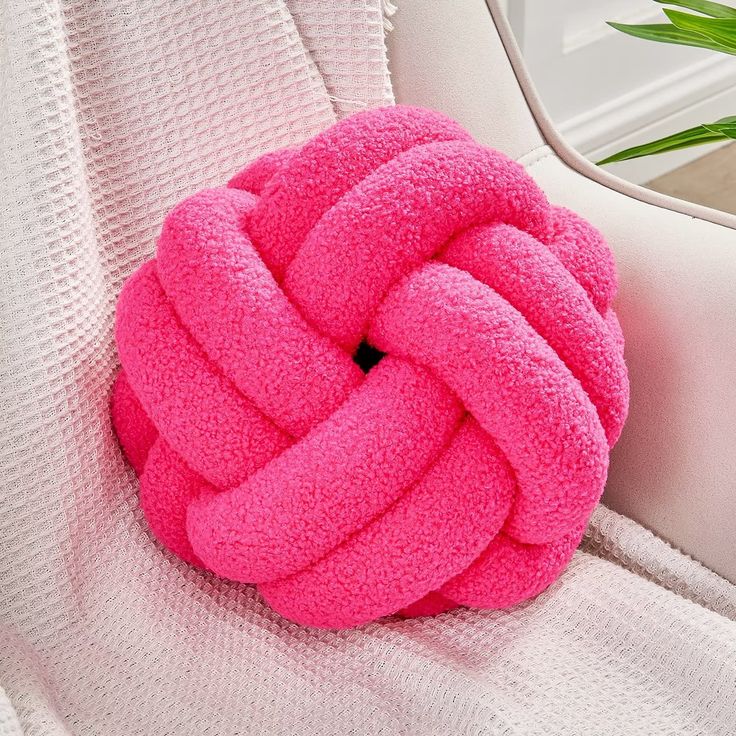 a pink knot sitting on top of a white couch