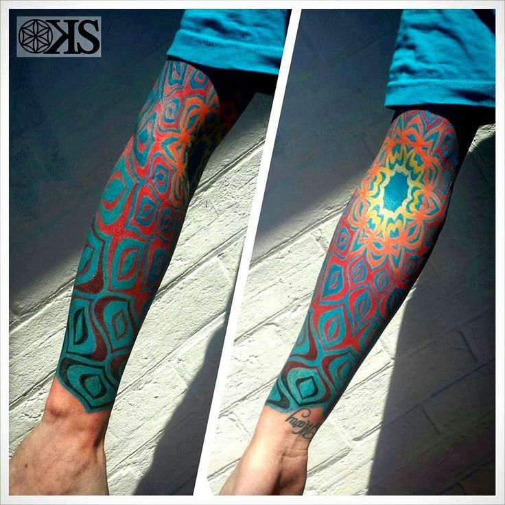 the arm is covered with colorful tattoos on both sides of it, and has an intricate design