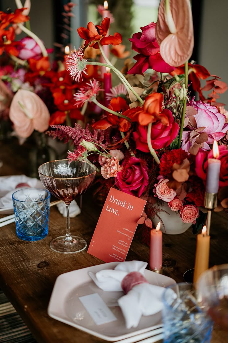 the table is set with flowers and candles