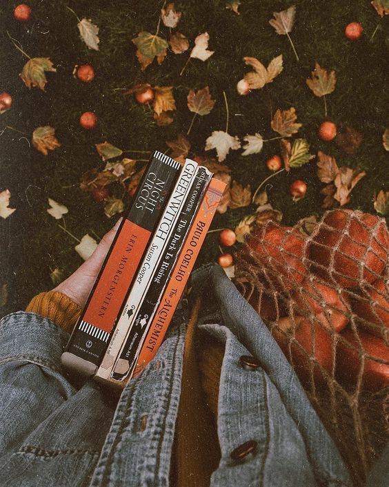 a person laying on the ground with some books in their lap