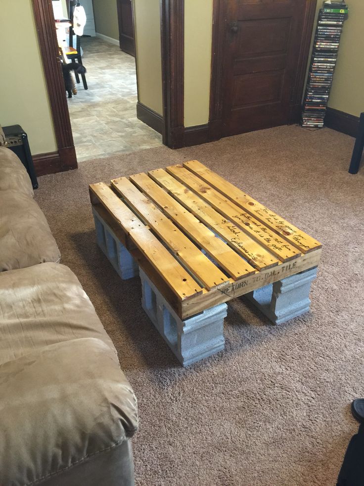 a wooden pallet sitting on top of a carpeted living room floor next to a couch