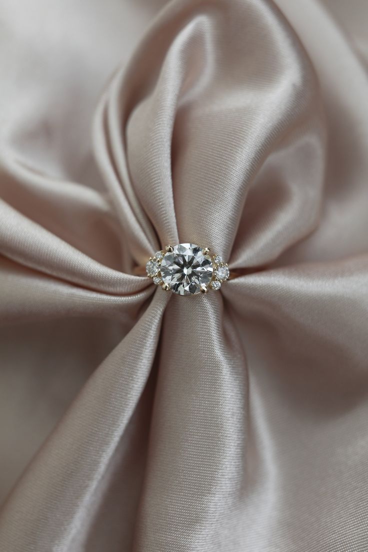 a close up view of a satin fabric with a diamond brooch in the center