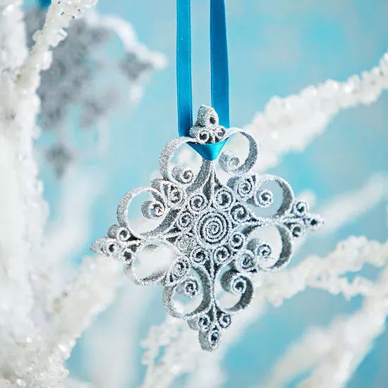 a snowflake ornament hanging from a blue ribbon