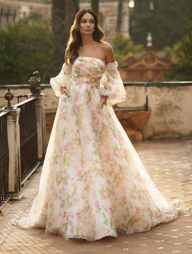 a woman in a long dress is standing on a brick walkway and posing for the camera