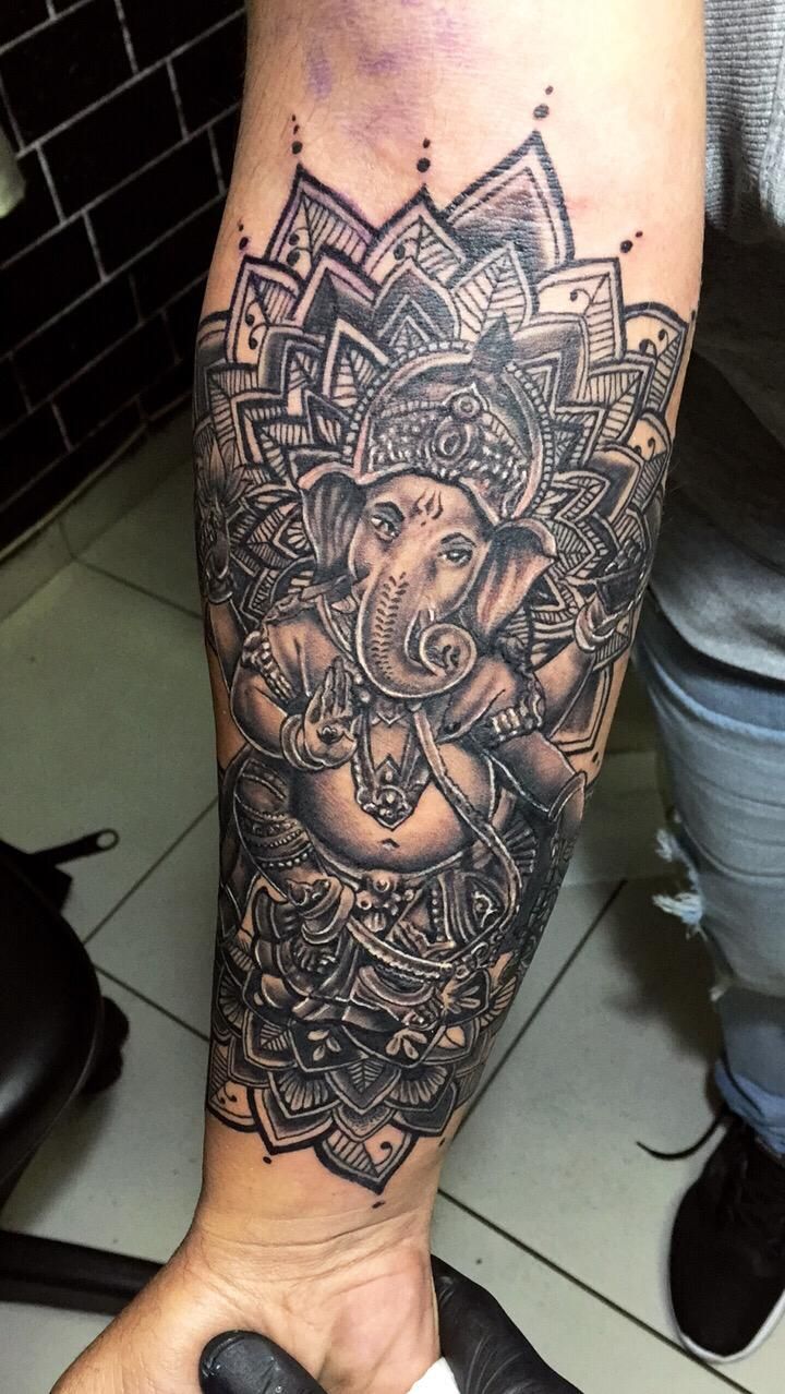 an elephant tattoo on the arm and leg is shown in black and grey ink with intricate designs