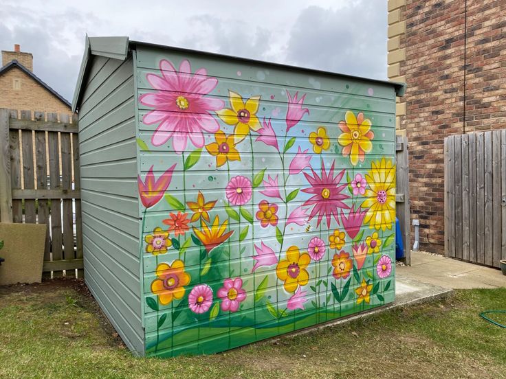 a painting on the side of a building with colorful flowers painted on it's sides