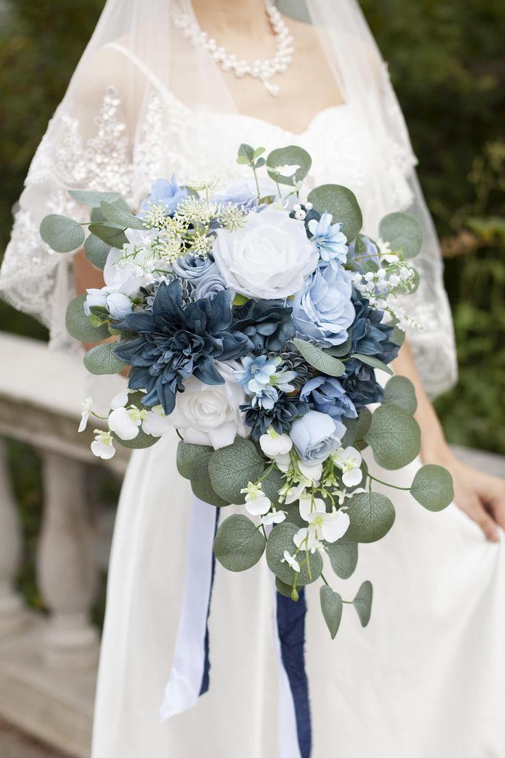 a bride holding a bouquet of blue and white flowers