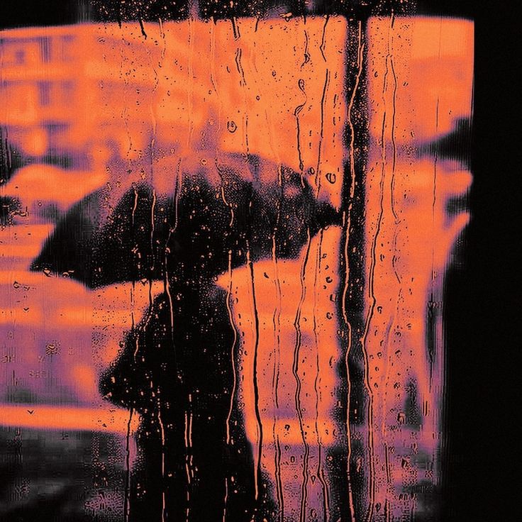 a person standing in the rain with an umbrella