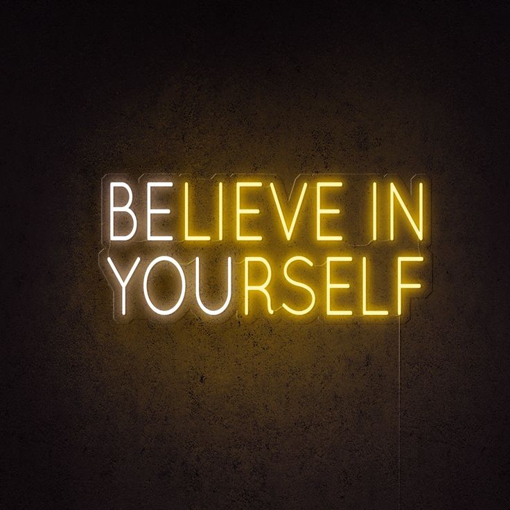 the words believe in yourself are lit up against a dark background with no one around them