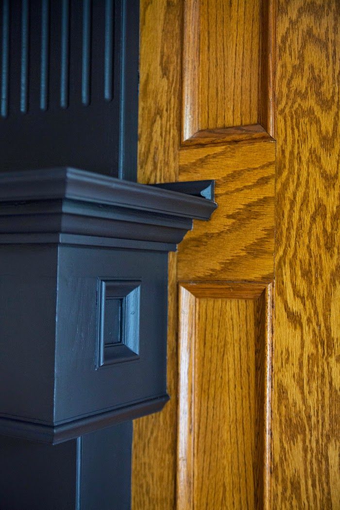 a close up of a wooden door with a black handle and wood grained paneling