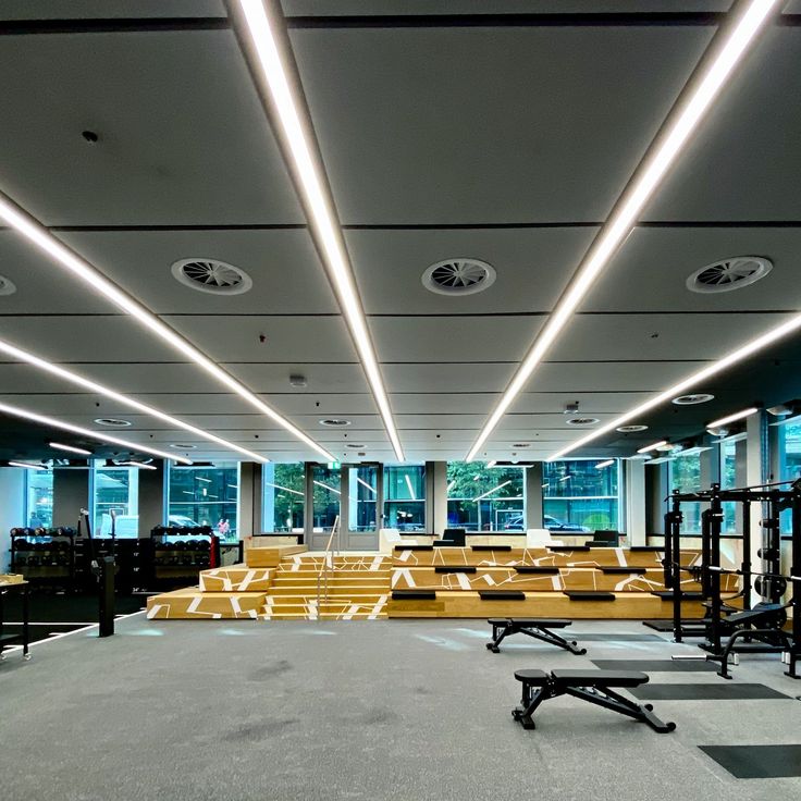 an empty gym with rows of benches and lights