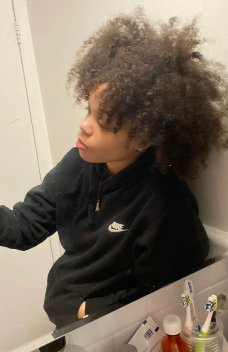 a young woman brushing her teeth in front of a mirror