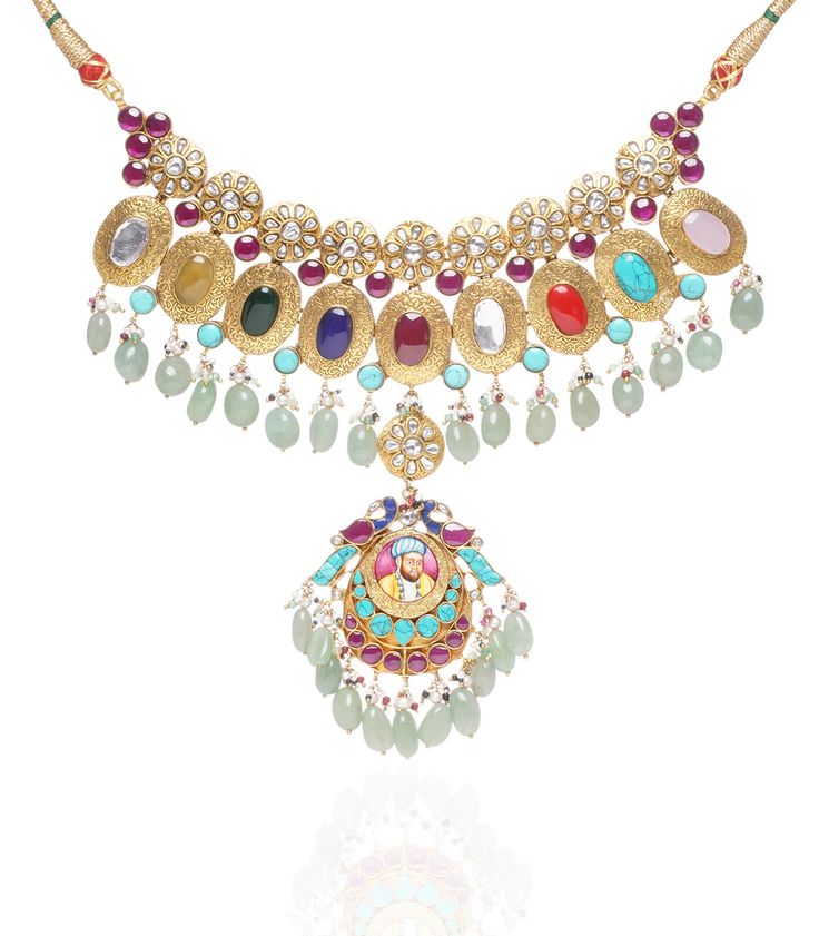 Step into refined elegance with the Jayaswi Navratan kundan necklace set, a breathtaking celebration of color and craftsmanship. Featuring an exquisite arrangement of navratan stones, each with its unique symbolism, this necklace radiates vibrancy and charm. Paired with matching earrings, this set is perfect for enhancing your festive looks, adding a touch of royal elegance to any occasion. Festive Multicolor 22k Gold Bridal Necklace, Multicolor 22k Gold Necklaces For Celebration, Traditional Multicolor 22k Gold Necklace, Traditional Multicolor 22k Gold Necklaces, Fusion Style Kundan Jewelry Sets With Gemstones, Multicolor 22k Gold Necklace For Diwali, Multicolor 22k Gold Bridal Necklace For Celebration, Fusion Kundan Gemstone Jewelry Sets, Festive Gemstone Jewelry Sets For Celebration