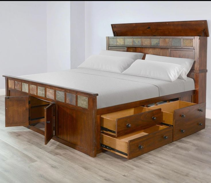 a bed with drawers underneath it and a white pillow on top of the headboard