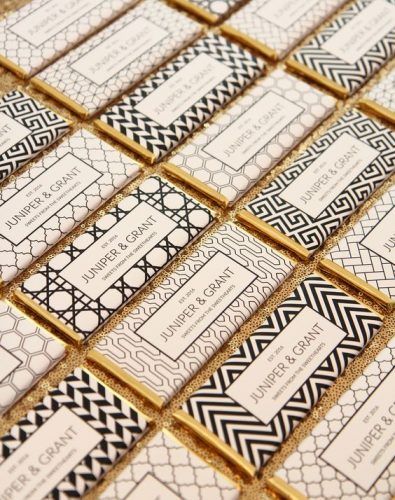 some black and white business cards with gold trimmings on top of each other