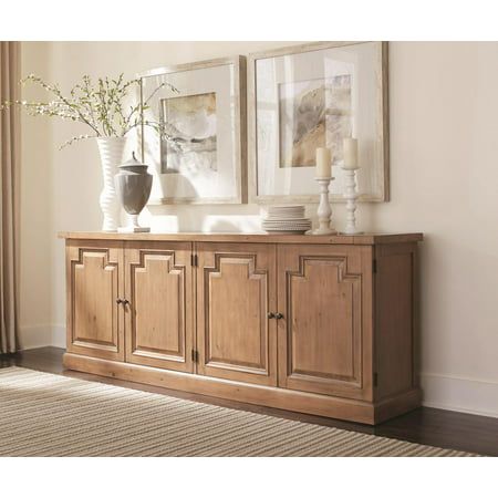 a wooden cabinet with two vases on top of it next to a rug and window