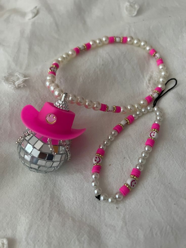 a necklace with a pink hat and beads on it