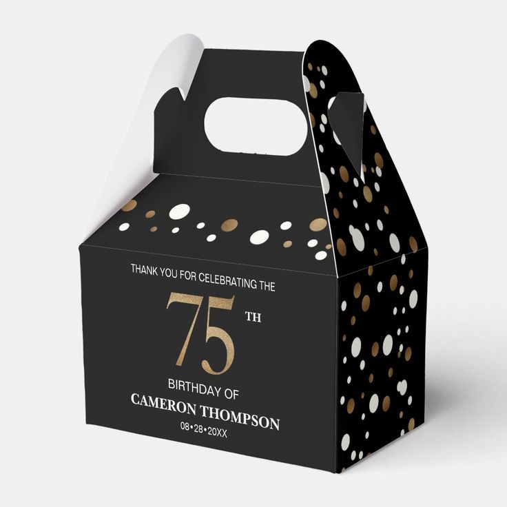 a black and gold birthday party box with white polka dots on the side, featuring an open lid