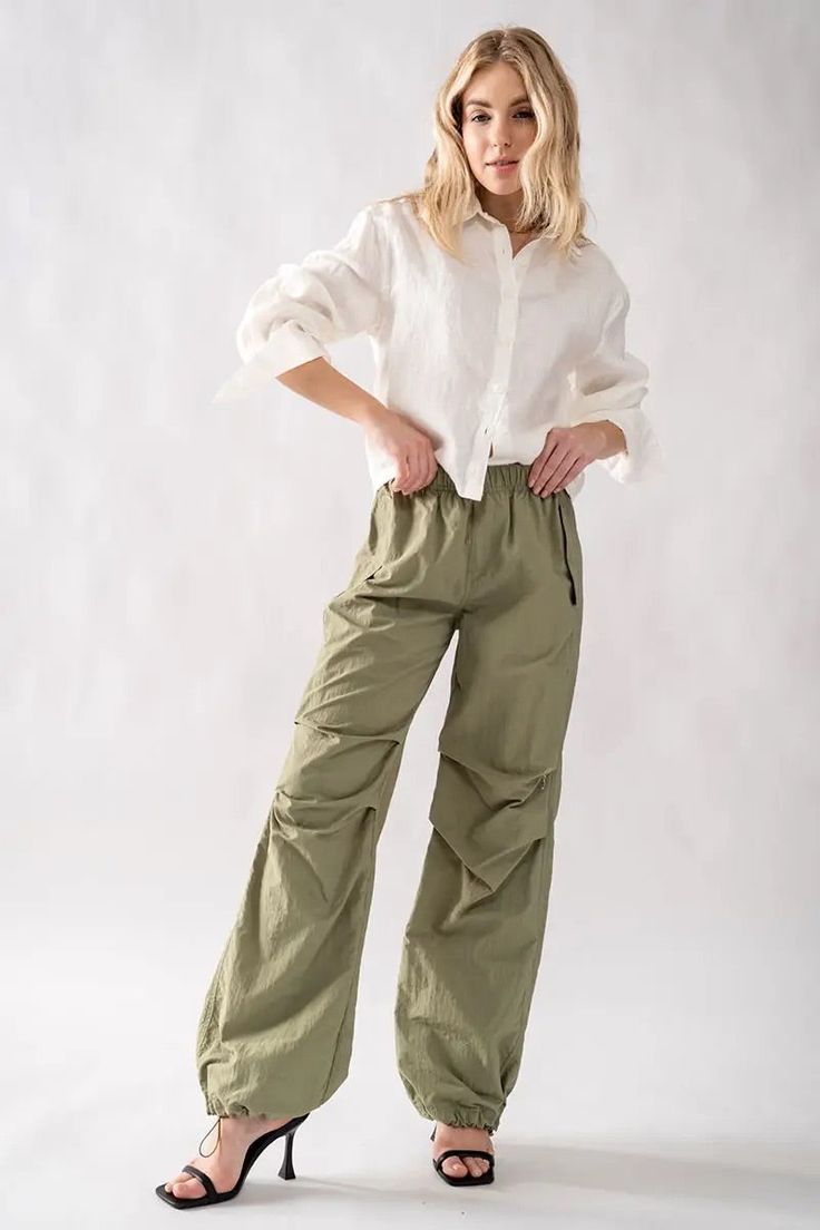 True to Size Fit Parachute Pants for a baggier fit please size up -flowing -adjustable Elastic Fastening At The Waist And Ankles Loose baggy parachute pants Earn some serious style points in these cargo bottoms. Featuring a olive shell material with a cargo design and extreme baggy fit, we're in love. Style with a crop top, fresh kicks and a mini bag for a look that brings all the attitude. Cargo Jogger Pants Outfit, Pantalon Parachute, Baggy Parachute Pants, Olive Shell, Celana Kargo, Leather Jogger Pants, Cargo Design, Christmas Clothing, Activewear Sets