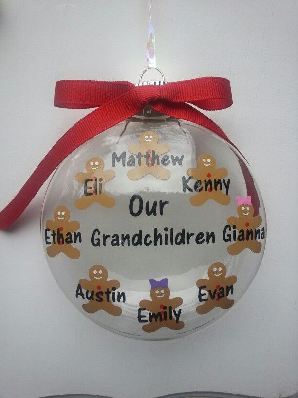 a glass ornament with gingerbreads on it hanging from a red ribbon