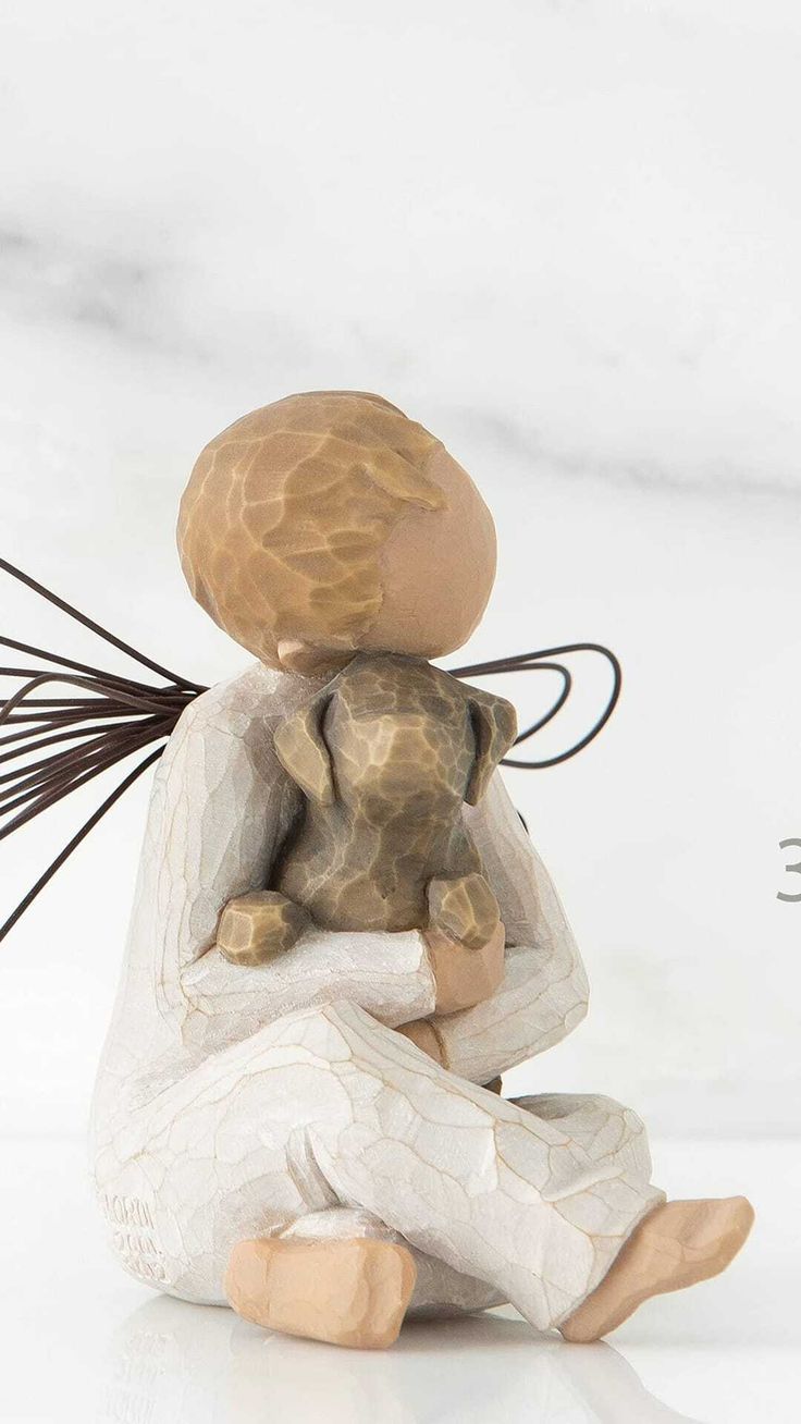 a small figurine sitting on top of a white table next to a plant