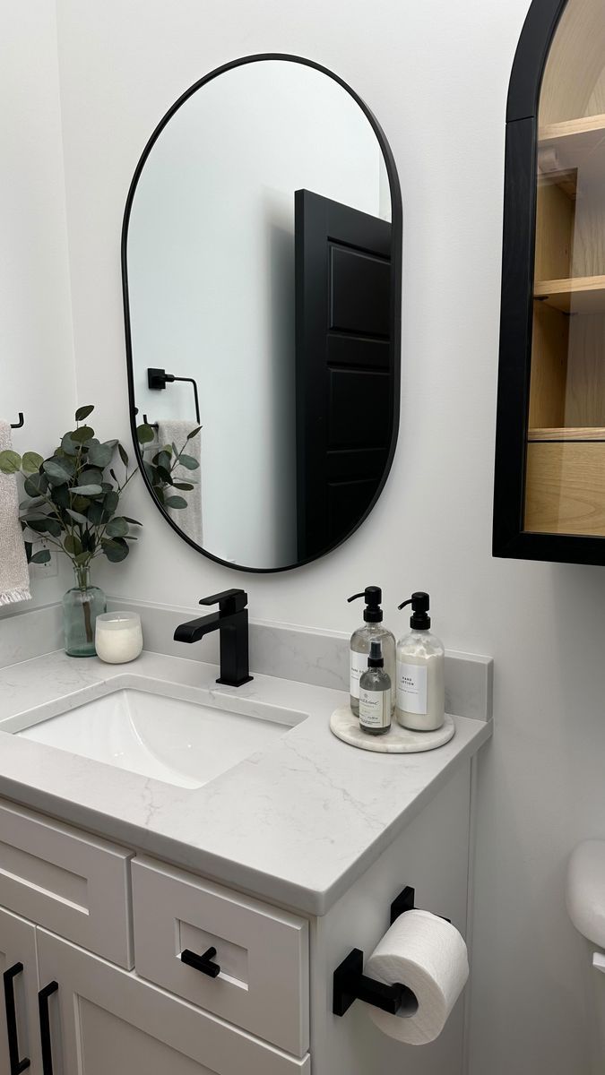 a bathroom with a sink, mirror and toiletries