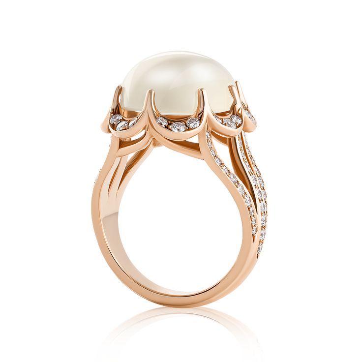 a pearl and diamond ring in rose gold with diamonds on the sides, set against a white background