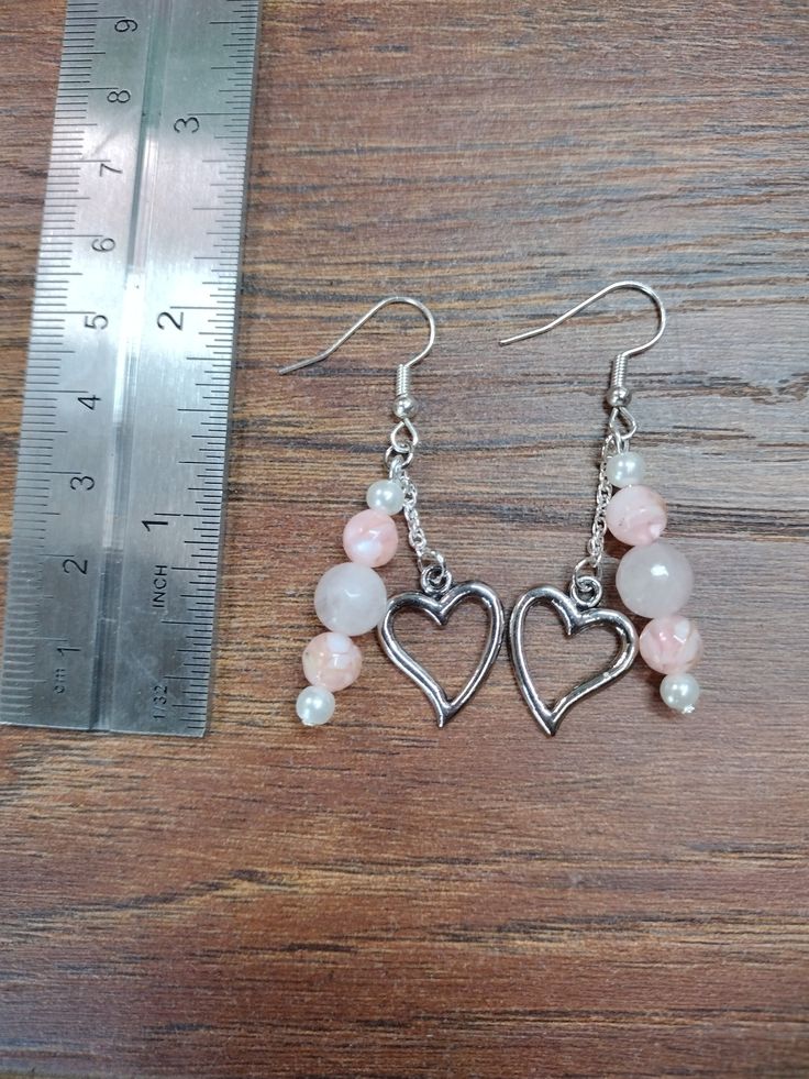 2 inch pink drop earrings. Silver heart charm attached by short silver chain. Sterling Silver Heart Beads Dangle Earrings, Metal Dangle Heart Earrings With Heart Charm, Pink Heart Charm Earrings, Pink Double Heart Sterling Silver Earrings, Pink Heart-shaped Sterling Silver Earrings, Pink Sterling Silver Heart Earrings, Metal Dangle Earrings With Heart Charm, Pink Heart Beads Sterling Silver Earrings, Pink Sterling Silver Heart Bead Earrings