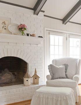 a living room with a white chair and fireplace in it's centerpieces