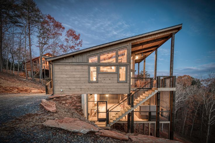 a small house with stairs leading up to the roof and windows on top of it