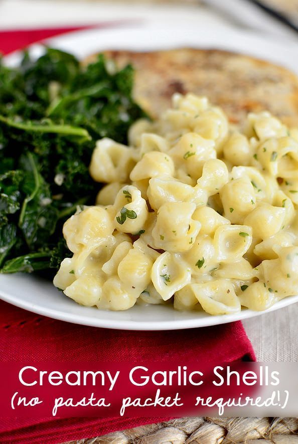 a white plate topped with macaroni and cheese next to spinach on a red napkin