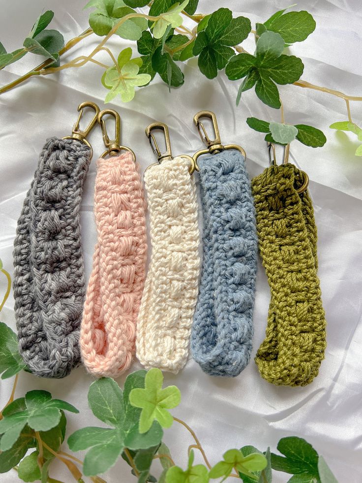 four crocheted key fobs are lined up next to each other