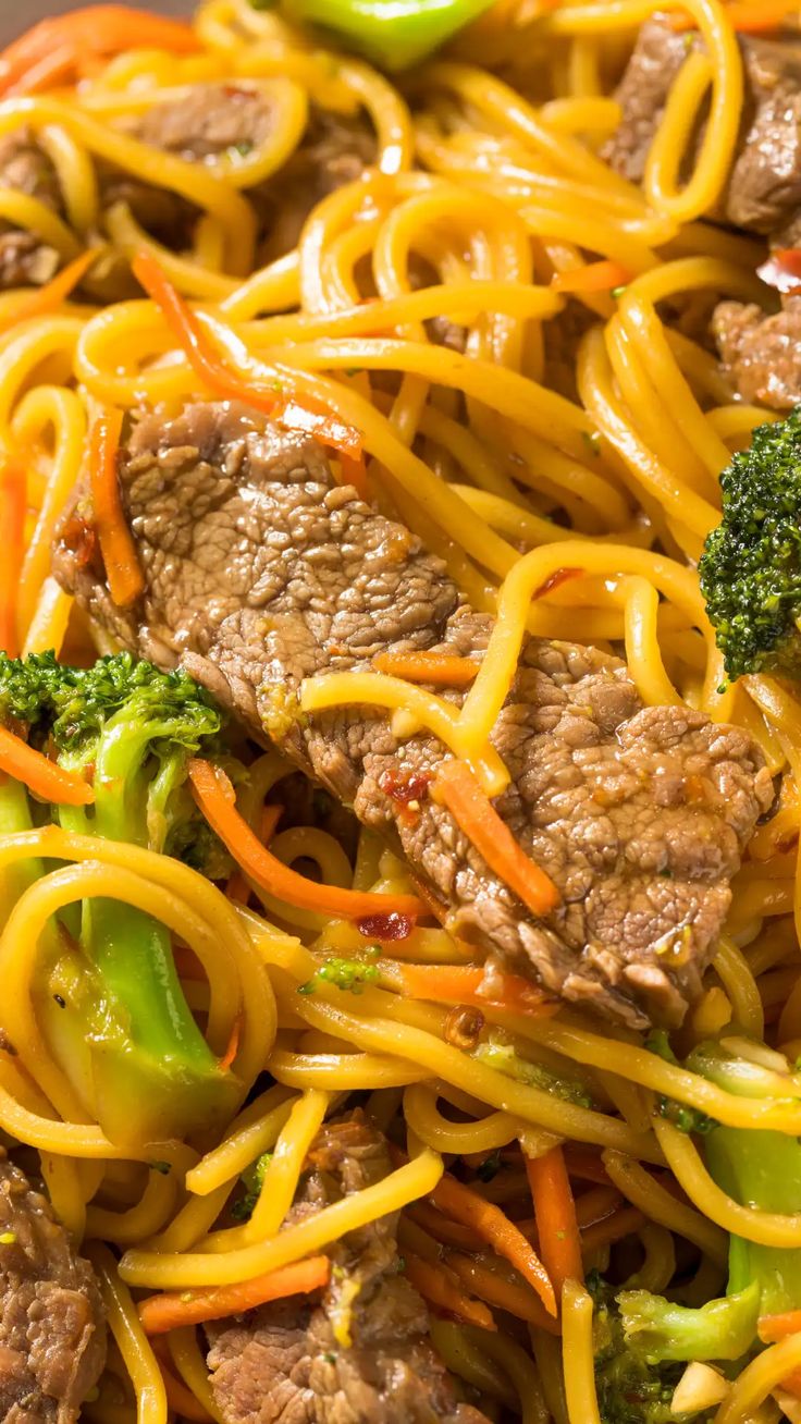 the noodles are mixed with meat, broccoli and carrots for a tasty looking dish