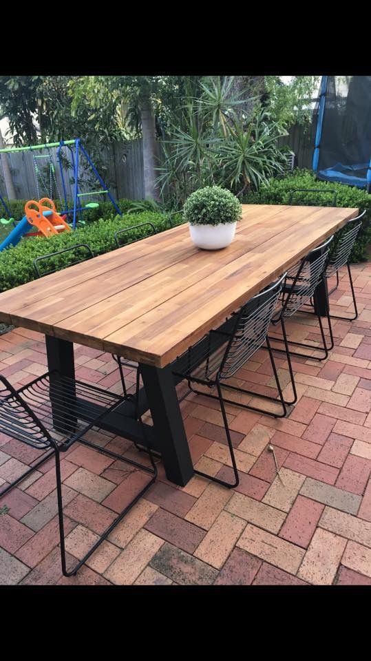 a wooden table sitting on top of a brick patio