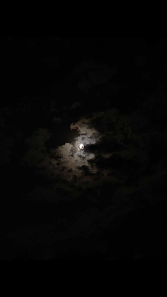 the full moon is shining brightly in the dark night sky with clouds and black background