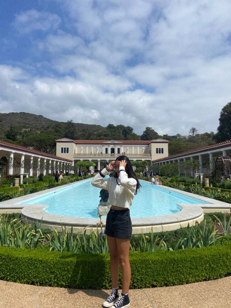 a woman taking a photo in front of a pool