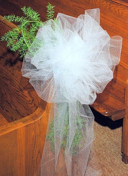 a bouquet of flowers sitting on top of a church pew