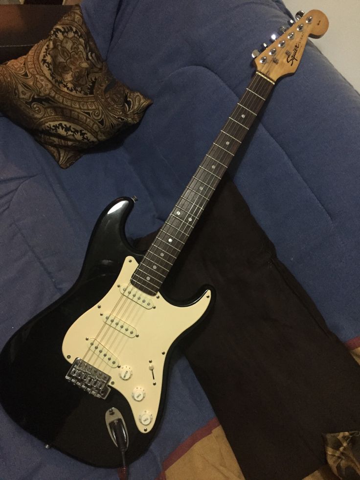 an electric guitar sitting on top of a blue couch