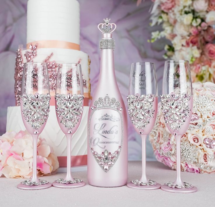 a table topped with pink wine glasses and a white cake covered in frosted icing