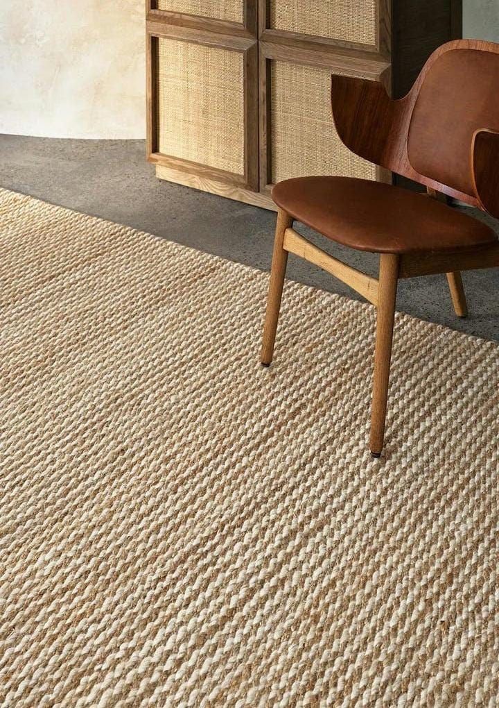 a wooden chair sitting on top of a rug