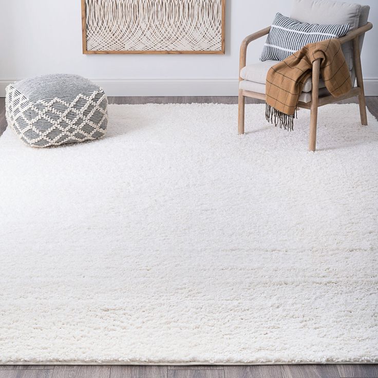 a living room with a white rug and chair